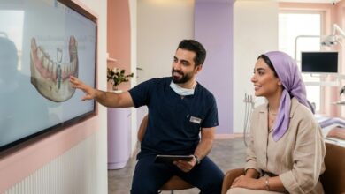 یک دندانپزشک آقای ایرانی و مجرب در حال توضیح دادن طرح درمان روی مانیتور به یک خانم